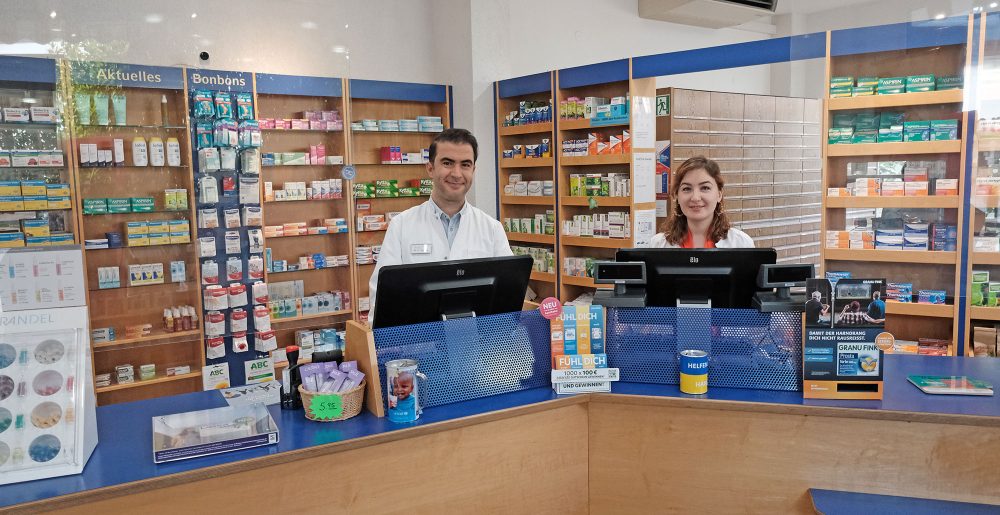 Zwei Mitarbeiterinnen der Heegbach Apotheke am Verkaufstisch vor den Medikamentenregalen